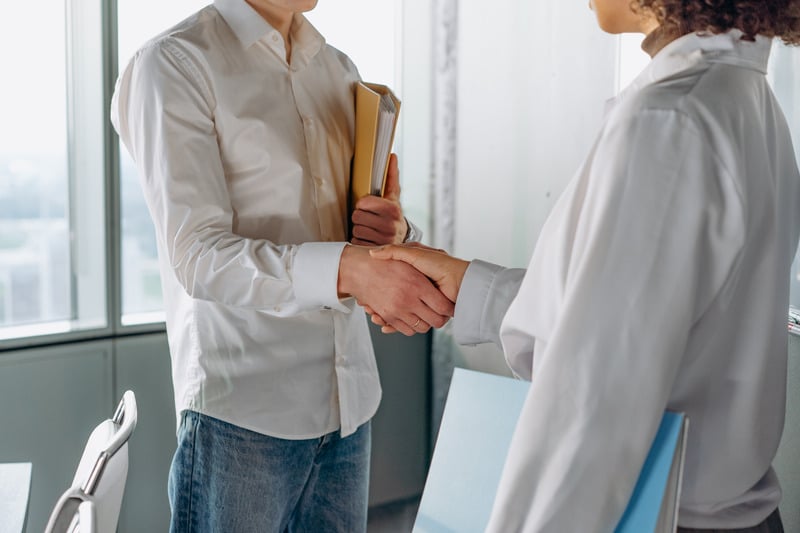 two people shaking hands in an office